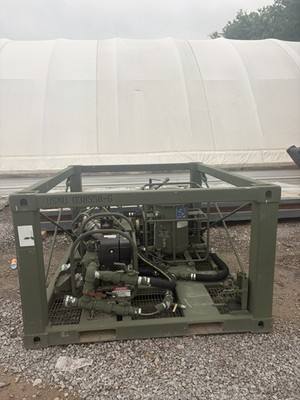 Olive-green military fuel transfer pump skid in a steel frame, seen from the front