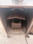 Open smoker door showing the interior heat box and baffle with soot and rust