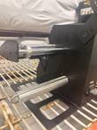 Label dispenser roller shafts and base plate, angled close-up