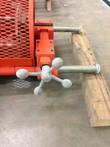 Four-arm gray hand wheel and two chrome guide rods of the pipe clamp, resting on a wood block