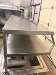 Two-tier stainless shelf and angled sneeze guard above the pan, with the utensil holder visible below
