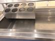 Empty stainless cold pan with an eight-hole utensil holder at one end, seen from above the front rail