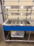 Atlas Metal refrigerated cold food counter, left end, with cold pan wells, glass sneeze guard and blue laminate panel