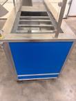 End three-quarter view of the cold pan wells and blue side panel on the Atlas Metal counter