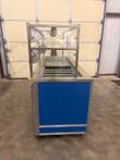 End view of the whole Atlas Metal cold food counter showing the sneeze guard, cold wells and blue side panel