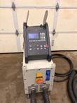 EFD MINAC induction generator on a shop floor with control console, main switch and water-cooled hoses attached