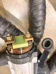 Head of an EFD MINAC handheld transformer with brass clamps, green insulator block and copper contact
