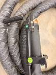 Handheld induction transformer with black handle, green buttons and a green TESTED OK sticker