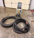 Whole EFD induction brazing system on a shop floor: generator cabinet and two coiled handheld cable assemblies