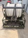 Front of the FireCombat ARFF skid unit: hose reel, twin nozzles, dry chemical and AFFF valves on an olive green frame