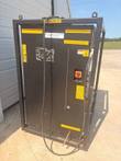 Black chiller in its steel frame at an angle, power cable over the top and the disconnect on the side.