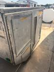 Angled side of the aluminum container with a hinged access door, mesh vent and chiller label.