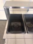 Two black steam table wells with cast Always Use With Water plates under a stainless overshelf.