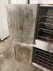 Open stained doors of a stacked Lang convection oven, wire racks visible in both cavities