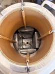 Looking down into a cryogenic storage tank, with four hanger rods and stainless storage racks inside