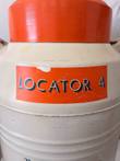 Cracked orange Locator 4 label below the orange lid on a cream cryogenic dewar