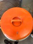 Top-down view of the orange insulated lid and handle on a cryogenic dewar