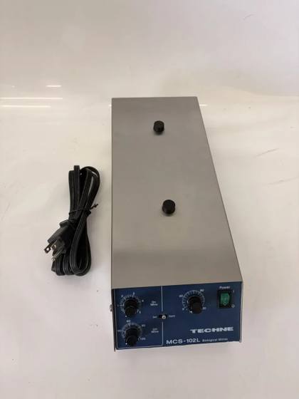 Techne MCS-102L Biological Stirrer, stainless steel top with two black knobs and blue control panel, power cord beside