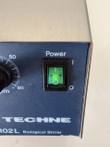 Green lit power switch and Techne MCS-102L Biological Stirrer label on the blue control panel