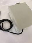 Cream pump drive housing from above and the side, with coiled black power cord