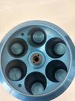 Inside the blue Sorvall rotor from above, six empty tube wells around the center hub
