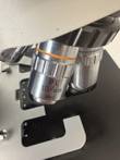 PL 10/0.25 objective with orange ring on the nosepiece above the black stage and slide holder