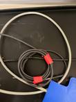 Coiled gray and black probe cables tied with red tape on a black tray