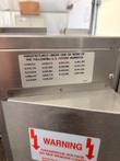 Patent number label and red hazardous voltage warning label on the Lincoln oven's side housing