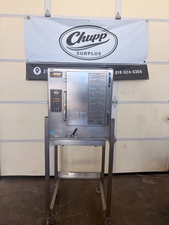 Front of AccuTemp Evolution boilerless steamer on a stainless stand with casters, in front of a Chupp Surplus banner