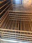 Five stacked wire oven racks with light rust spotting, angled view inside the oven cavity