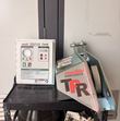 Poweramp iDock vehicle restraint control panel next to the galvanized TPR dock lock unit