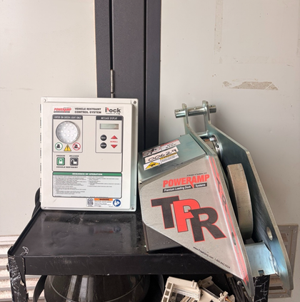 Poweramp iDock vehicle restraint control panel next to the galvanized TPR dock lock unit