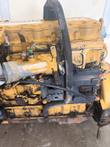 Side of the Caterpillar engine with black electronic control module, wiring, air inlet pipe and oil pan
