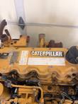Caterpillar valve cover with the Caterpillar decal, engine information labels and turbocharger behind