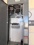 Gray motor control center cabinet with upper door open, showing starter, fused disconnect and five motor protectors