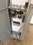 Open motor control center cabinet showing contactor, three green fuses and a row of motor circuit protectors
