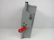 Gray fusible safety switch seen from the side, red operating handle and mounting flange