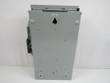 Back of a gray fusible safety switch enclosure, with keyhole mounting slot and conduit knockouts