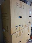 Stacked brown cartons marked Battery Charger with weight, dimension and handling symbols