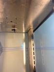Hatco cabinet interior ceiling with humidity fitting and slotted stainless shelf-rack rail beside the glass