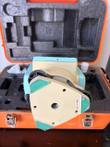 Underside of the theodolite tribrach with three green-marked corners, center mounting hole and Made in China label