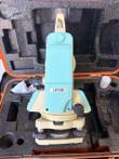 Teal and cream LDT-05 digital theodolite on its tribrach, sitting in an orange hard case with foam insert