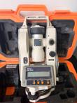 Nikon NE-20S digital theodolite resting in its open orange hard case with foam inserts