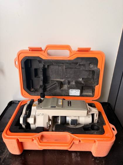Nikon NE-20S electronic theodolite resting in its open orange hard case with foam inserts