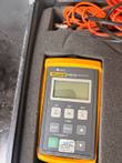 Fluke FM150 fiber meter with LCD, keypad and a calibrated sticker, sitting in its foam cutout