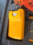 Back of an orange Fluke unit in its foam cutout, with Fluke Corporation Made in USA label