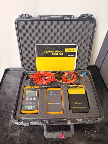 Open Fluke FTK200 kit with manual, FM150 fiber meter, FS150 fiber source, black module and cords in foam