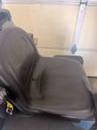 Black molded operator seat of the Nilfisk Liberty SC60 with a retractable strap on the side