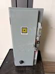 Closed gray Square D enclosure with logo, ON/OFF (RESET) handle and red lockout