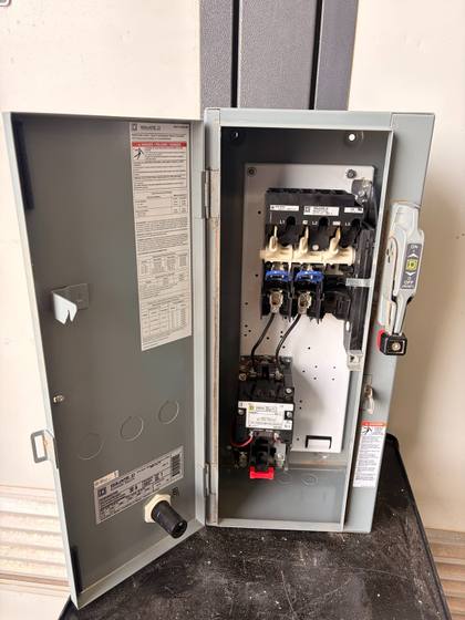 Enclosure with the door open, disconnect and contactor visible